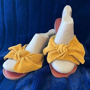 AMERICAN EAGLE. MUSTARD SLIP ON SANDALS. SUADE LIKE MATERIAL. LARGE BOW AS STRAP